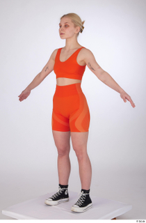 Unaisa a-pose dressed orange bike shorts orange sports bra standing…